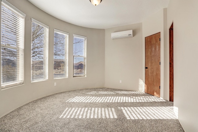 spare room with a wall mounted AC and carpet