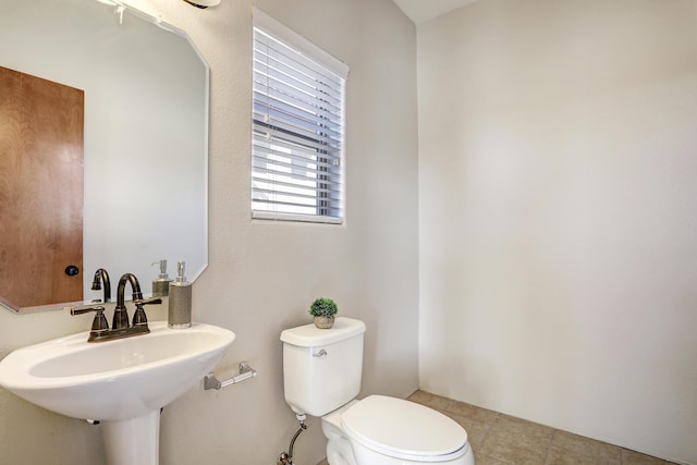 bathroom featuring toilet, tile patterned flooring, and sink