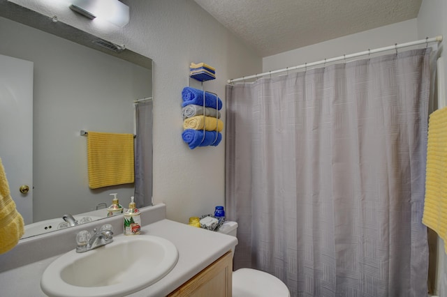 bathroom featuring vanity, toilet, and a textured ceiling