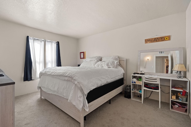 bedroom featuring light carpet and a textured ceiling