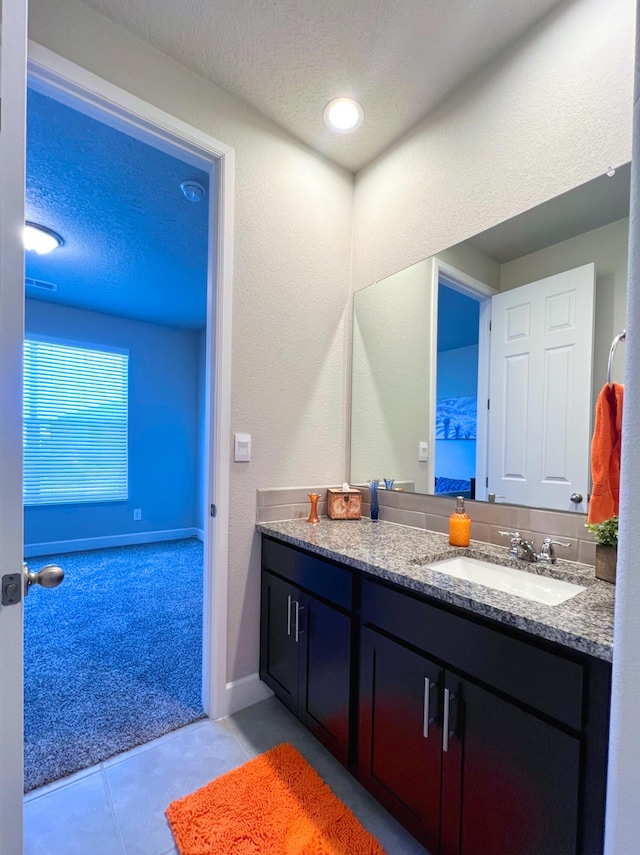 bathroom featuring vanity, tile patterned floors, and a textured ceiling