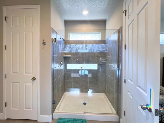 bathroom featuring walk in shower and a textured ceiling