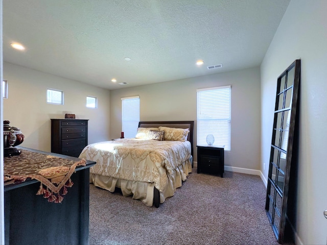 bedroom featuring a textured ceiling and carpet flooring