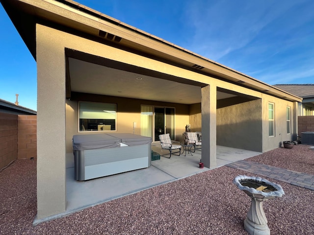 view of patio / terrace with central AC and a hot tub