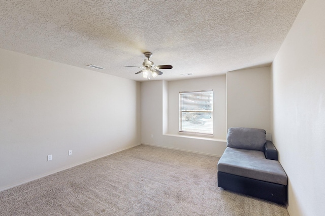 unfurnished room with ceiling fan, visible vents, a textured ceiling, and light colored carpet