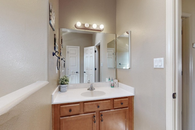 bathroom with a textured wall and vanity