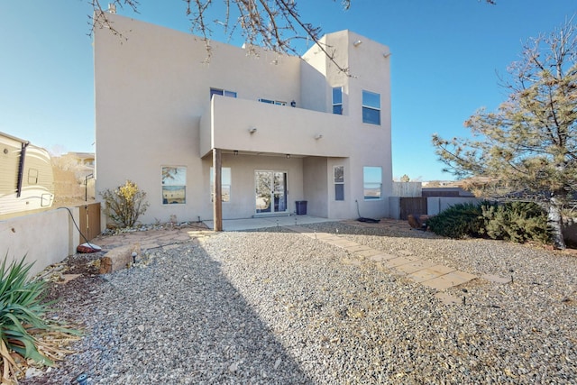 back of house with a fenced backyard, a patio, and stucco siding