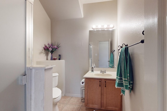 bathroom with toilet, vanity, baseboards, and tile patterned floors