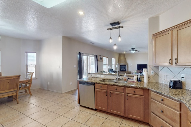 kitchen with dishwasher, a sink, light stone countertops, and a healthy amount of sunlight