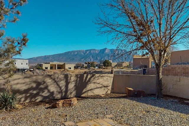 view of yard with a residential view, fence, and a mountain view