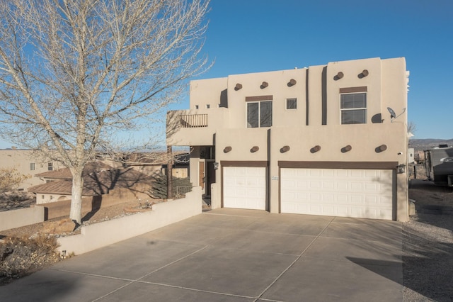 view of home's exterior with driveway, a balcony, a garage, and stucco siding