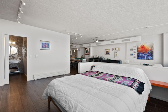 bedroom with dark hardwood / wood-style floors, a textured ceiling, and baseboard heating