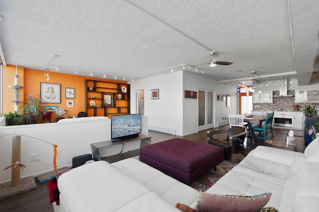 living room with dark wood-type flooring, track lighting, a textured ceiling, and ceiling fan