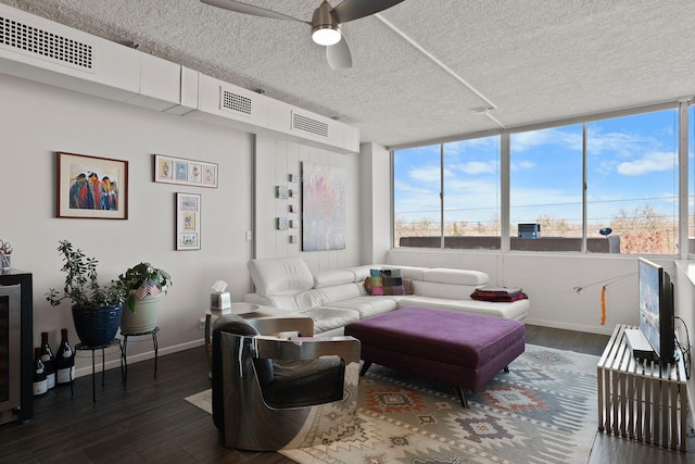 living room featuring dark hardwood / wood-style flooring, a textured ceiling, and ceiling fan