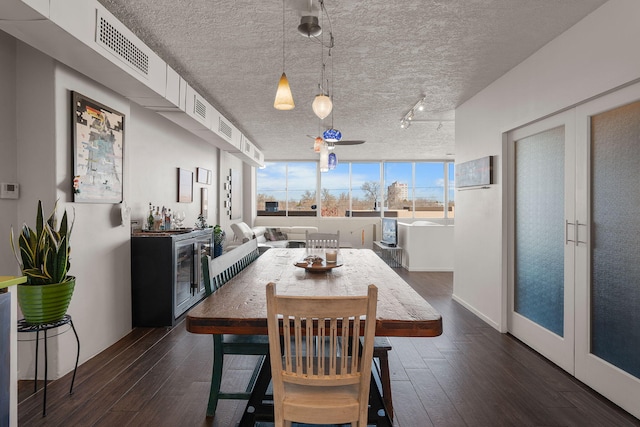 dining space featuring dark hardwood / wood-style floors, beverage cooler, and rail lighting