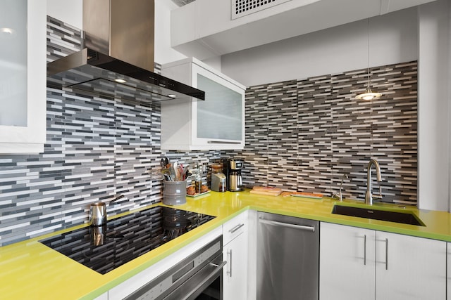 kitchen featuring sink, backsplash, stainless steel appliances, white cabinets, and wall chimney exhaust hood