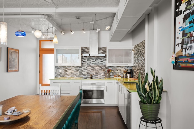 kitchen featuring ventilation hood, white cabinetry, oven, backsplash, and hanging light fixtures