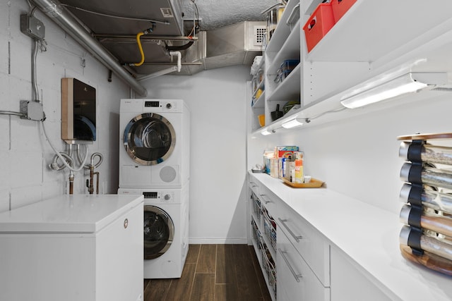 clothes washing area with stacked washer / drying machine and dark wood-type flooring