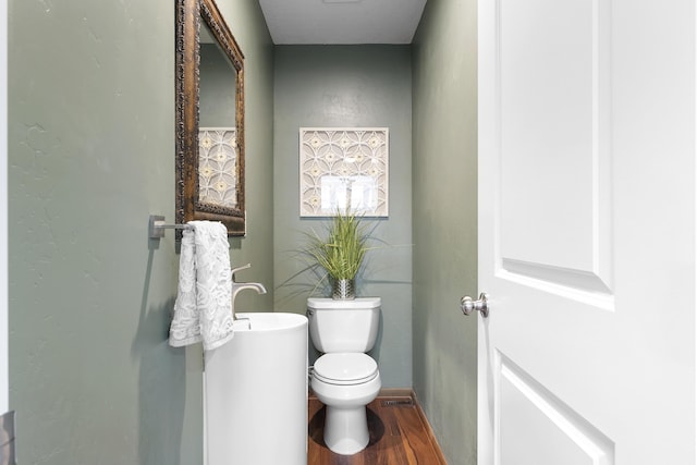 bathroom featuring hardwood / wood-style flooring and toilet