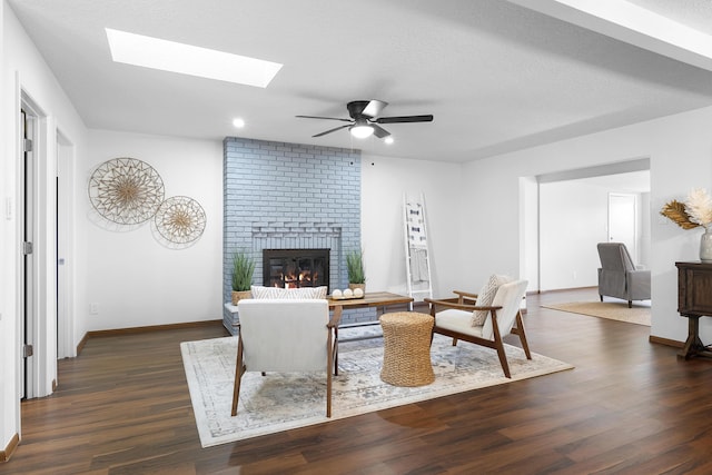 living room with ceiling fan, dark hardwood / wood-style floors, a textured ceiling, and a fireplace