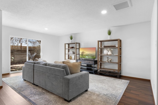 living room featuring dark hardwood / wood-style floors and a textured ceiling