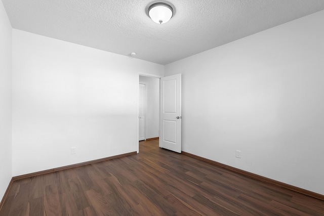 spare room with dark wood-type flooring and a textured ceiling