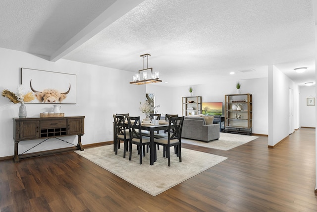 dining space with dark wood-type flooring, beam ceiling, a chandelier, and a textured ceiling