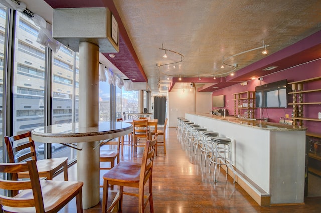 kitchen featuring rail lighting, hardwood / wood-style floors, and a textured ceiling