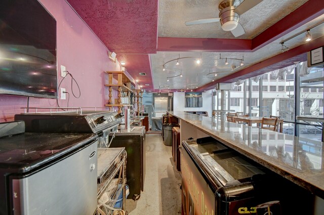 kitchen with ceiling fan and a textured ceiling