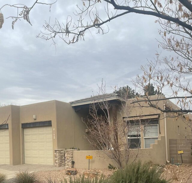 pueblo-style house featuring a garage