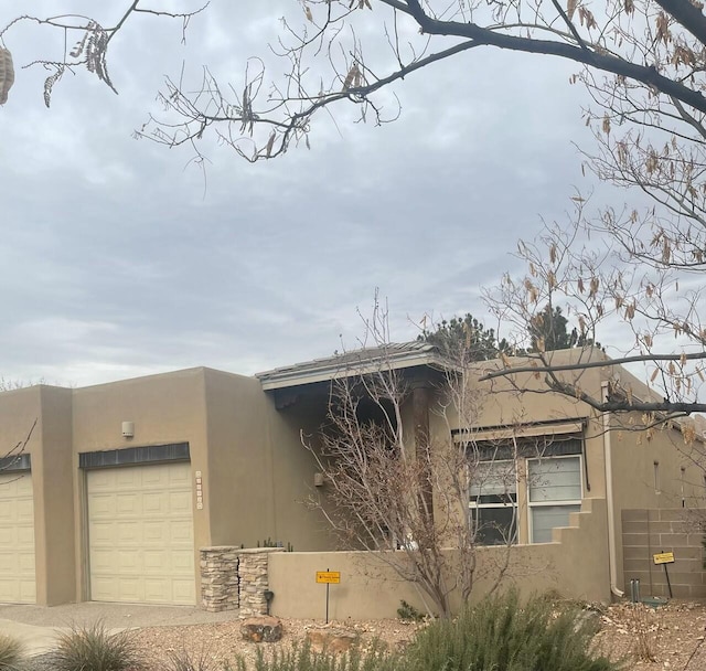 pueblo-style home featuring a garage