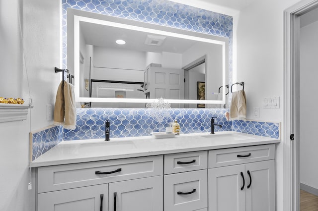 bathroom featuring vanity and backsplash