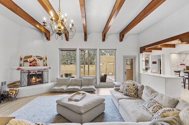 living room with beam ceiling, a chandelier, and light hardwood / wood-style flooring