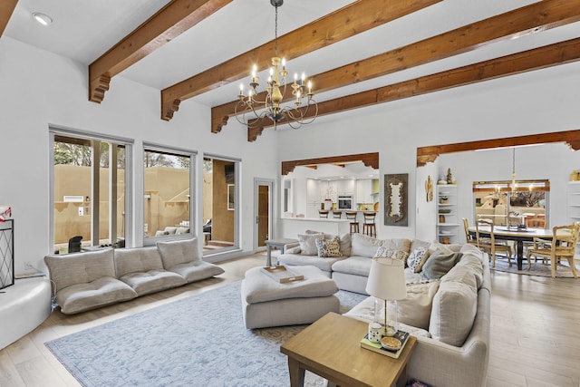 living room featuring beam ceiling, light hardwood / wood-style floors, and a notable chandelier