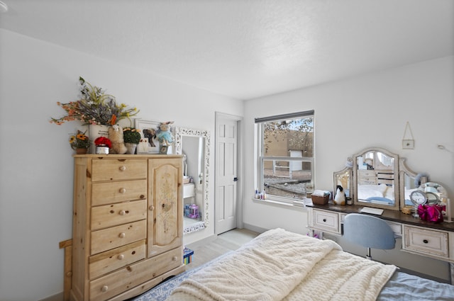 bedroom featuring light hardwood / wood-style flooring and built in desk