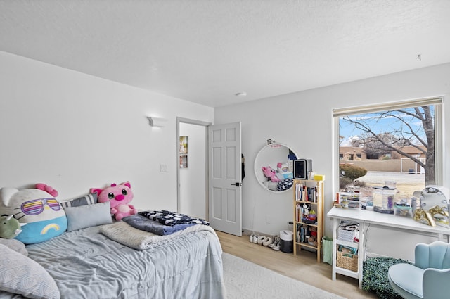 bedroom featuring light hardwood / wood-style flooring and a textured ceiling