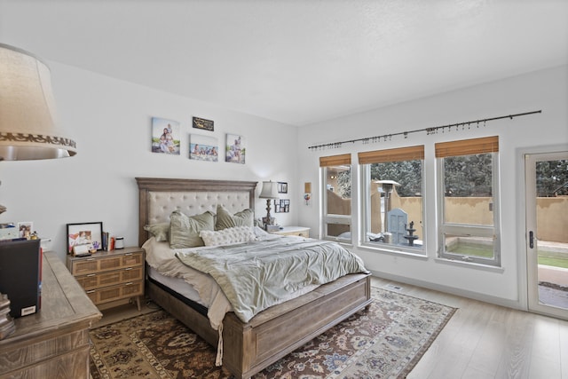 bedroom with hardwood / wood-style floors and access to outside