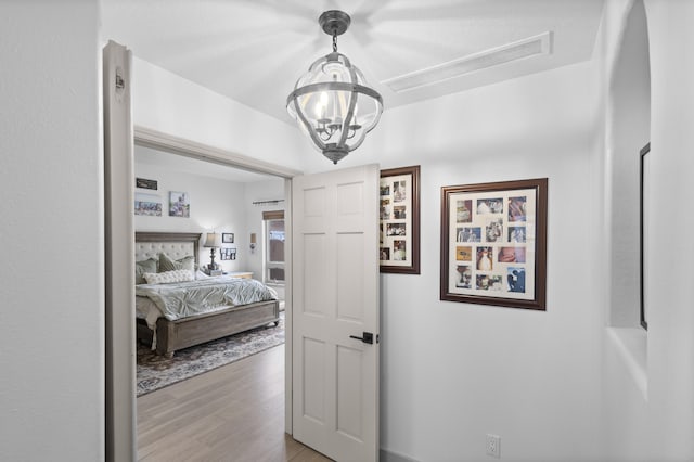 bedroom featuring light hardwood / wood-style flooring and a notable chandelier