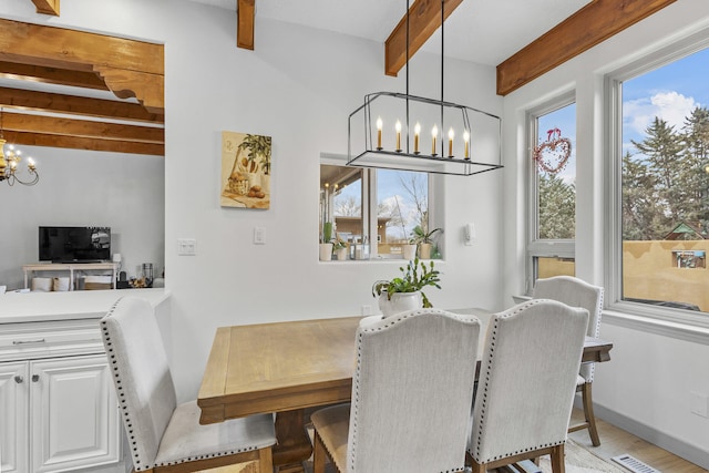 dining room featuring a notable chandelier, beam ceiling, and light hardwood / wood-style floors