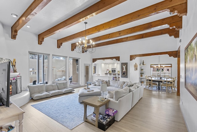 living room featuring an inviting chandelier, light hardwood / wood-style floors, and beamed ceiling