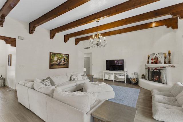 living room with beam ceiling, hardwood / wood-style floors, and an inviting chandelier