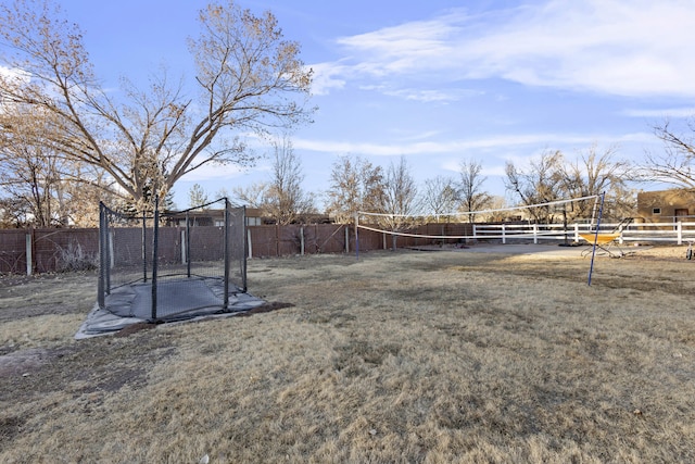 view of yard with a trampoline and volleyball court