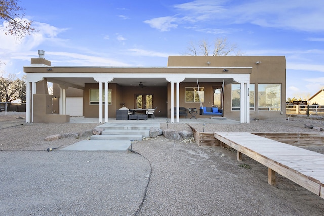 back of property featuring ceiling fan, outdoor lounge area, and a patio area