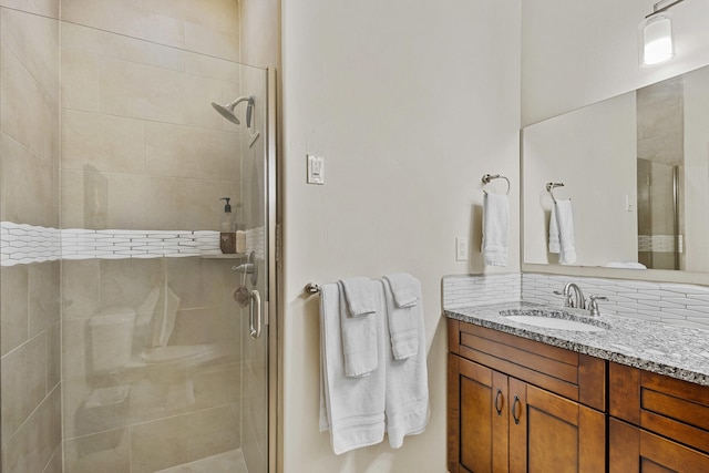 bathroom with vanity, backsplash, and walk in shower