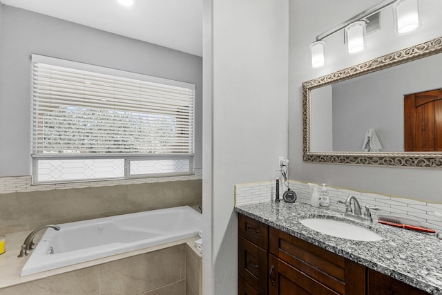 bathroom with vanity and tiled bath