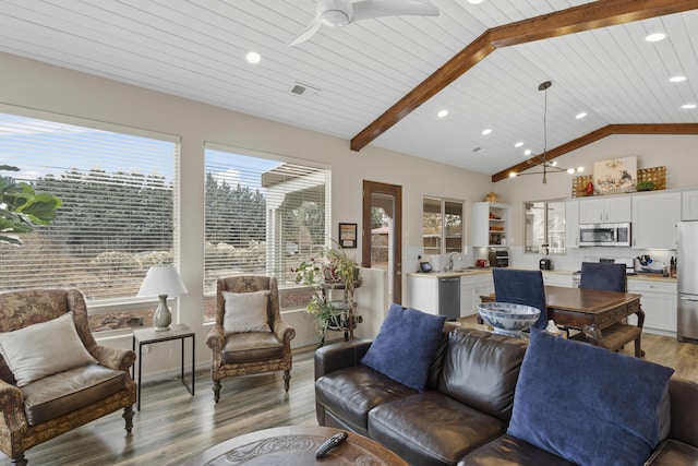 living room featuring sink, vaulted ceiling with beams, wood ceiling, light hardwood / wood-style flooring, and ceiling fan