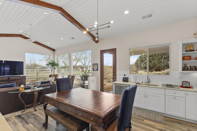 dining area with sink, vaulted ceiling with beams, wood ceiling, and light hardwood / wood-style floors