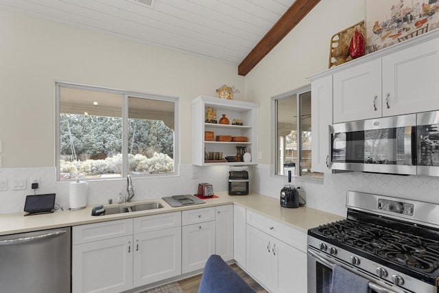 kitchen featuring lofted ceiling with beams, white cabinetry, stainless steel appliances, and sink