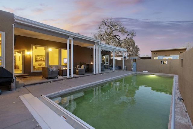 pool at dusk with a patio, outdoor lounge area, and a pergola