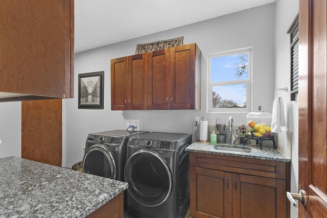 clothes washing area featuring sink, cabinets, and washing machine and clothes dryer